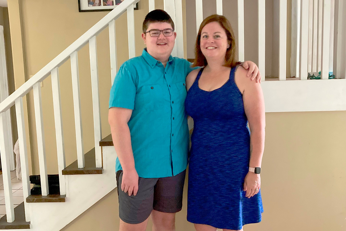 A young blood cancer survivor stands with is mother