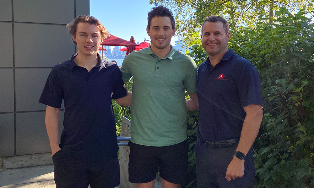 three young men standing with arms linked
