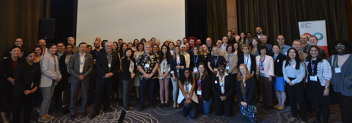 A photos of all Research Day attendees. An arrow is pointing toward Travis, so you can pick him out in the crowd.