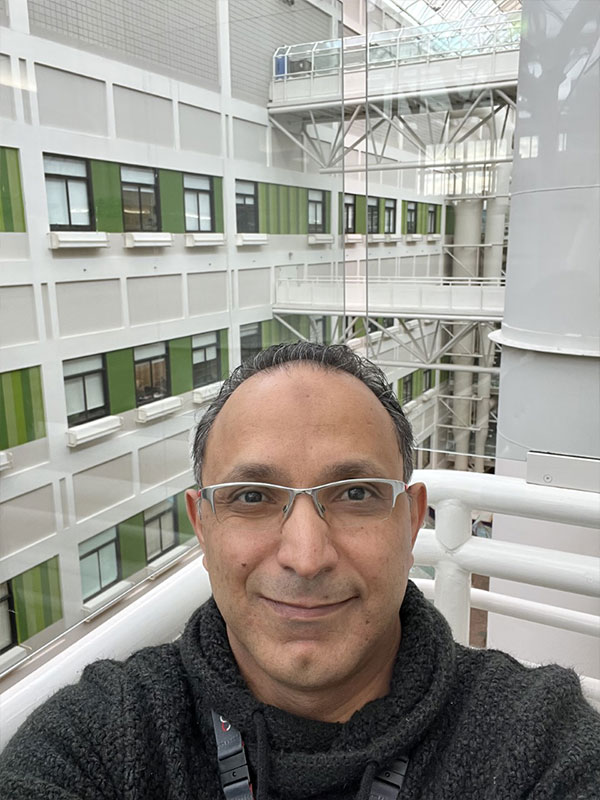 Dark grey haired man with glasses taking a selfie