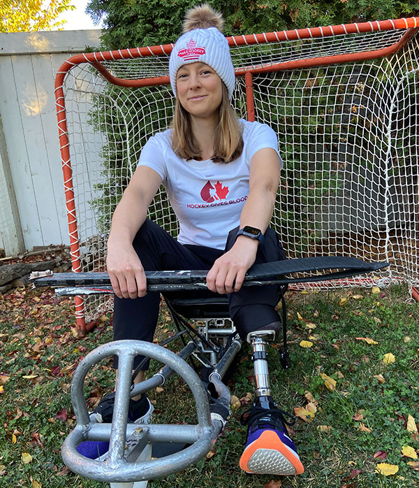 Para hockey player sitting on sled wearing a Hockey Gives Blood T-shirt