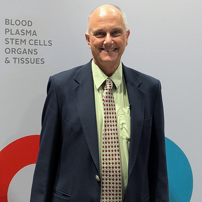Dr. Bill Sheffield in front of a Canadian Blood Services banner stand