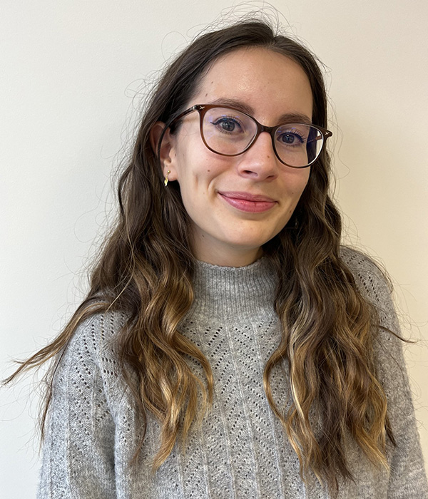 Justine Hanotaux with long brown hair and a grey sweater