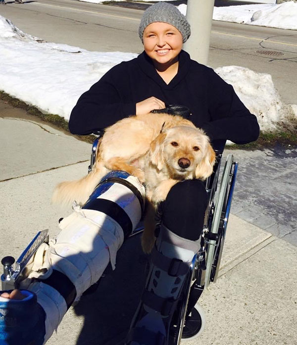 Cancer survivor Lara Turner in a wheelchair with a dog