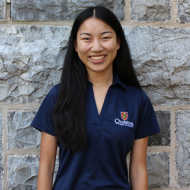 Liliana Chow standing in front of a stone wall.