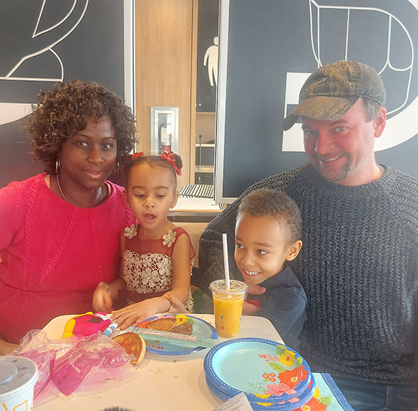 Cord blood donor Simone with her two children and husband at a restaurant table