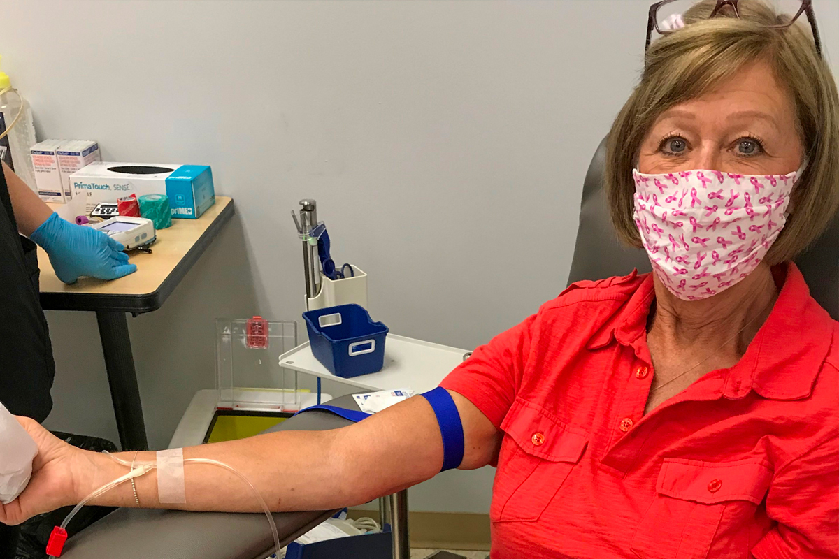 A breast cancer survivor donates blood after cancer recovery.