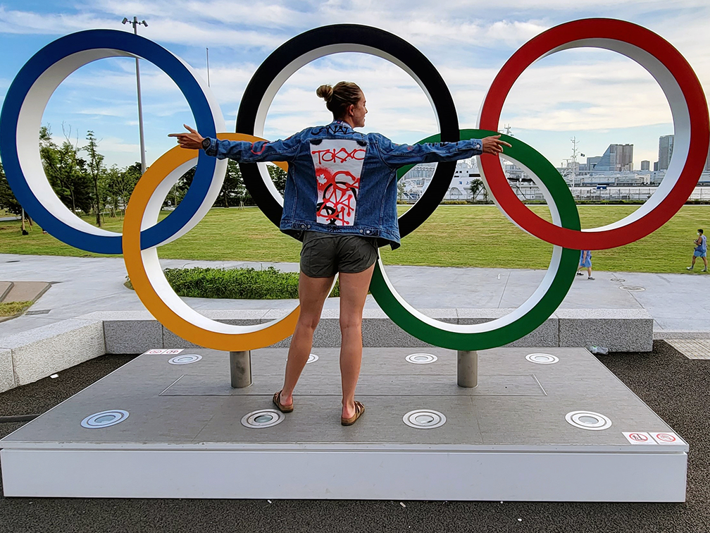 Olympic gold medallist Andrea Proske in Team Canada jacket in front of Olympic rings in Tokyo