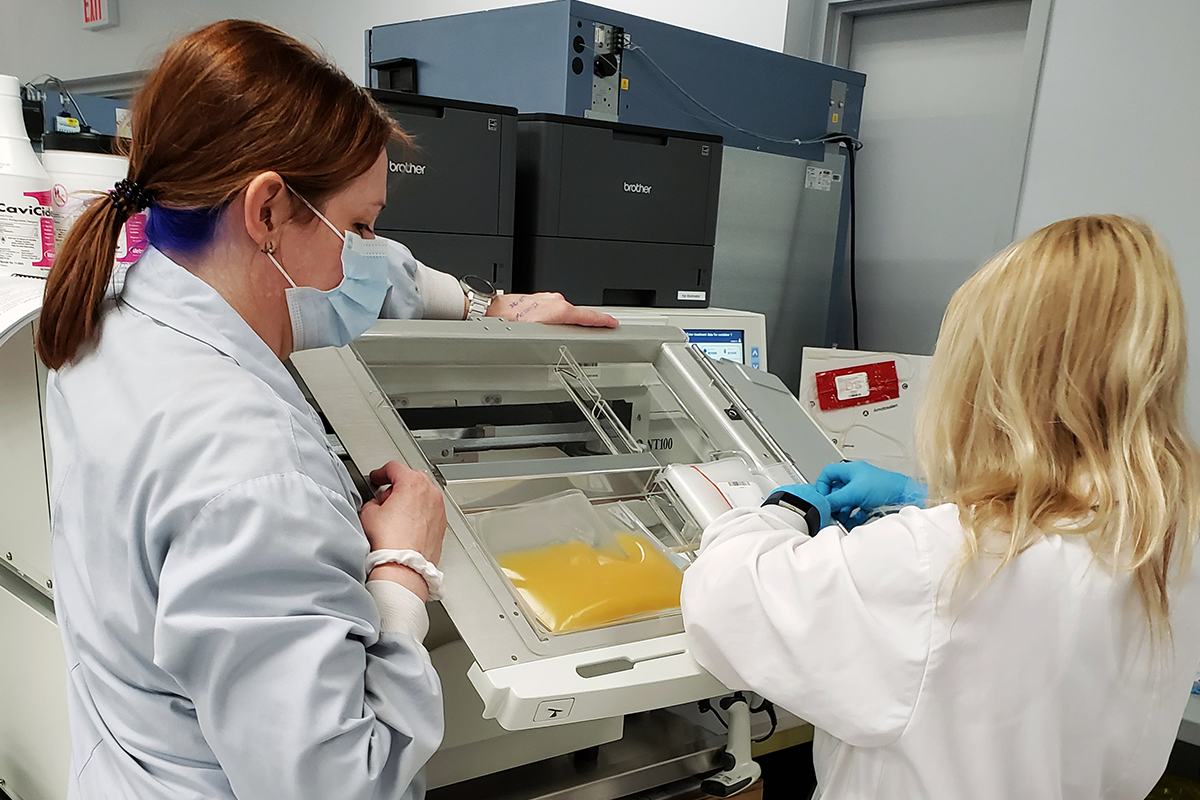 two women inserting units of platelets into a pathogen inactivation machine
