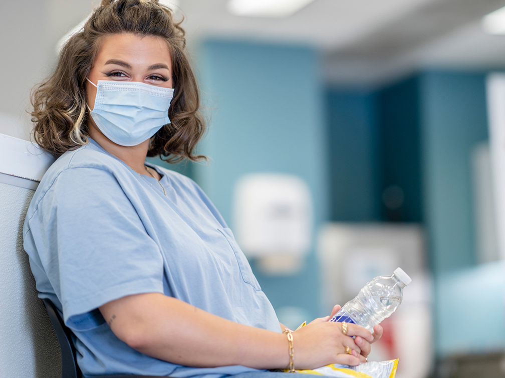 a nurse smiling with a mask on