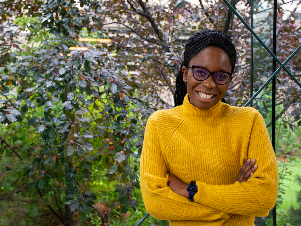 Stem cell advocate Sylvia Okonofua poses with a smile by a garden.