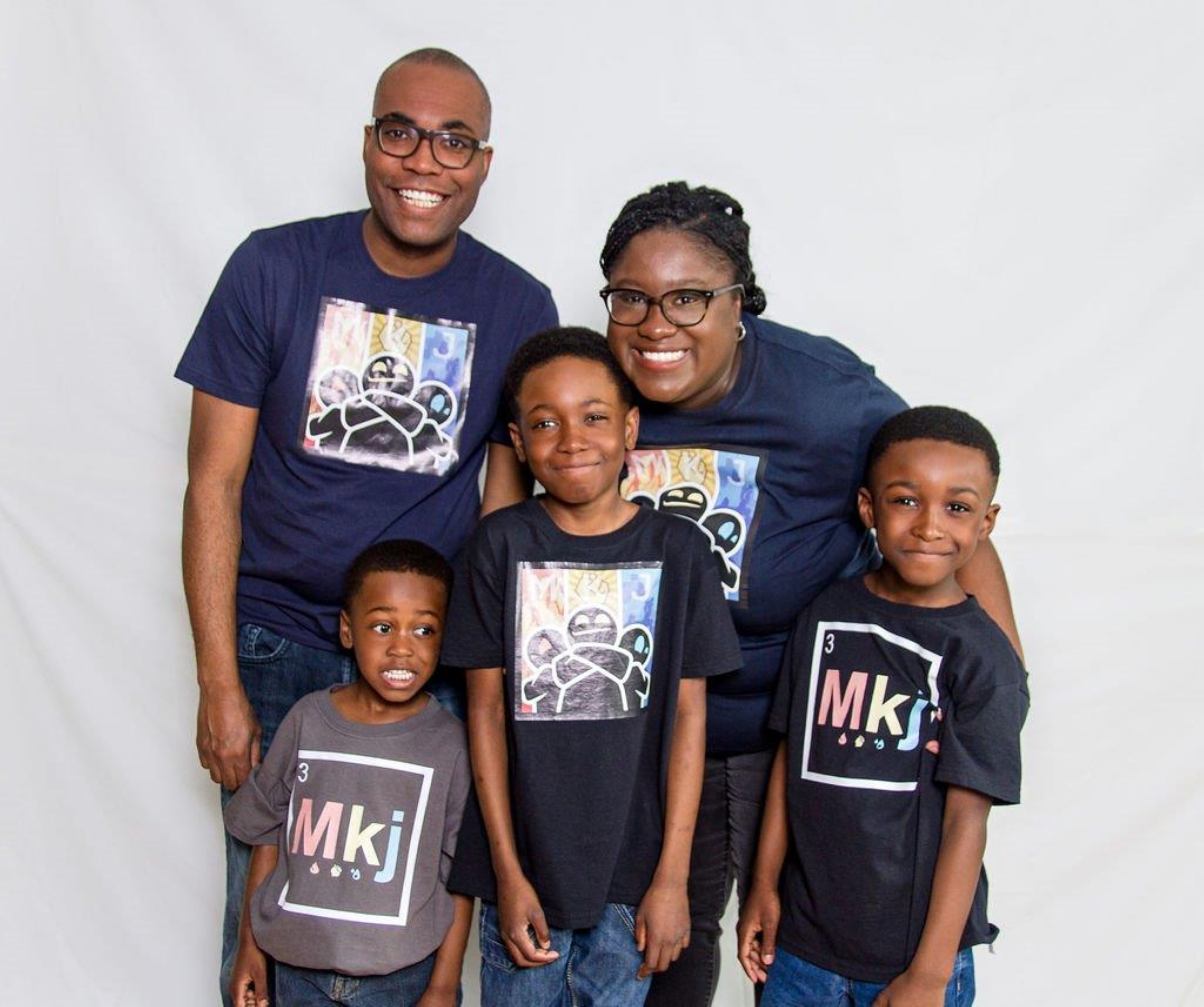 Nahomie Acelin and her husband Ronald Felix pose with their three sons in promotional T-shirts for Nahomie’s book The Battle of Ottogatz.