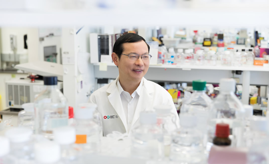 Dr. Heyu Ni Image of Dr. Heyu Ni in a lab with test tubes and empty tubes