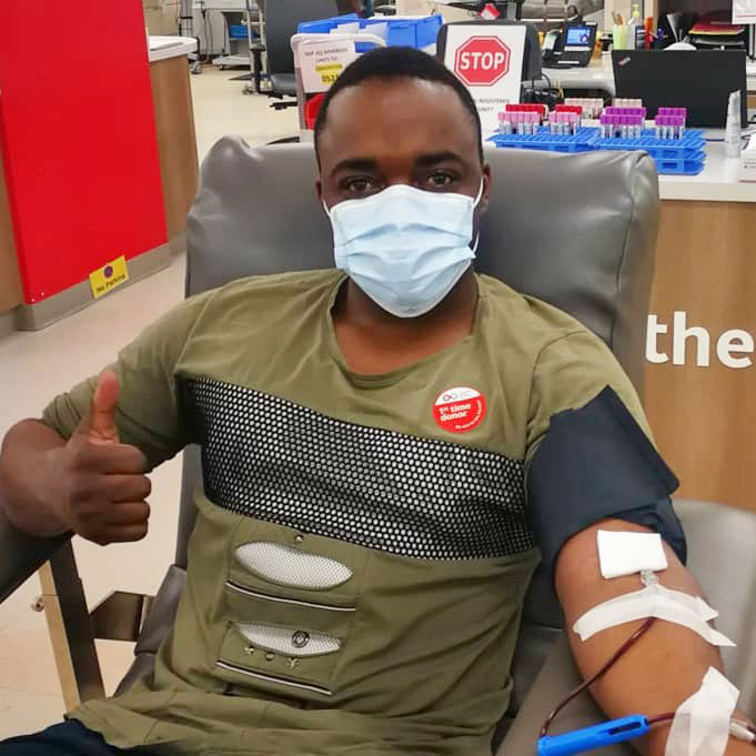 Young donor sitting in donation chair, giving a thumbs up