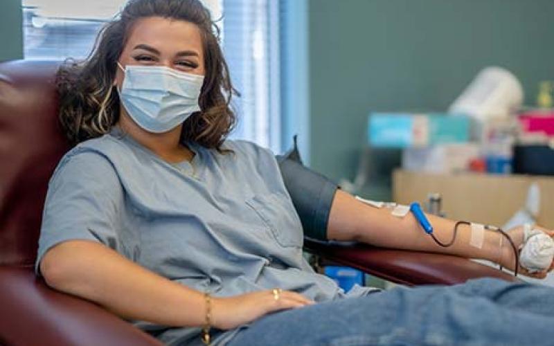 Young woman at donor centre donating blood