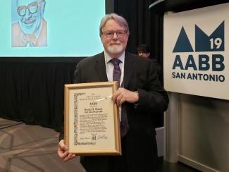 Dr. Donald Branch holds his award at the AABB annual meeting in San Antonio