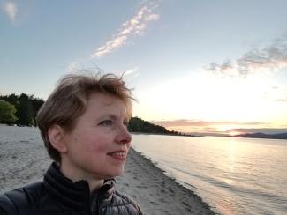 Dr. Elisabeth Maurer staring into the Jericho Beach standing on the sand.