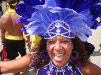 Anika McDonald celebrates Caribbean Days Festival in purple costumes.