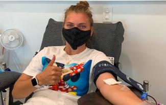 Image of white girl wearing a face mask donating blood.