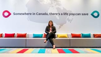 Image of Territory manager for Calgary, Alberta, Jhoanna Del Rosario sitting on a sofa at the Workplace of the Future at the new Canadian Blood Service Operational Facility