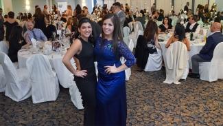 Pictured is Filomena Germano and Jenn Bruno in dresses at a gala standing in front of tables with people