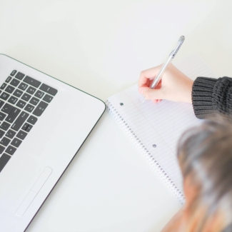 a woman writes on a notepad