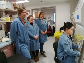 2.	Training international students to perform the monocyte monolayer assay. Charlotte Paquet (France), Mairead Holton (Ireland), and Elodie Dupeuble (France) watch Selena Cen (Branch laboratory, Canadian Blood Services) perform the monocyte monolayer assay.