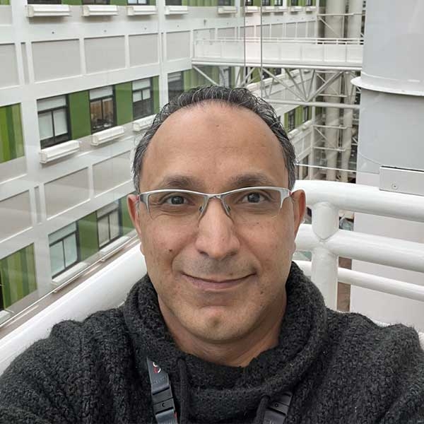 Dark grey haired man with glasses taking a selfie