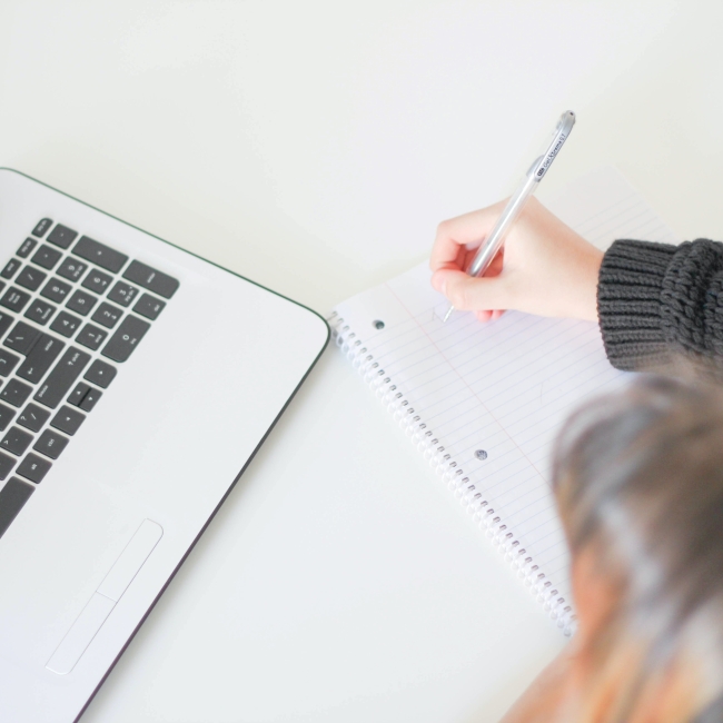 a woman writes on a notepad