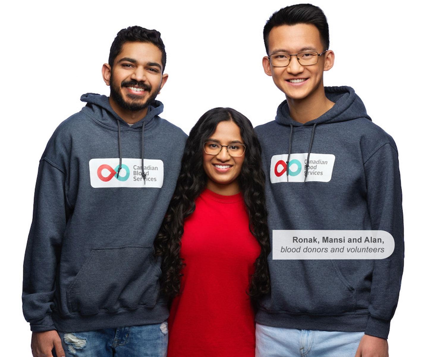 Three blood donors wearing Canadian Blood Services hoodies and a red shirt