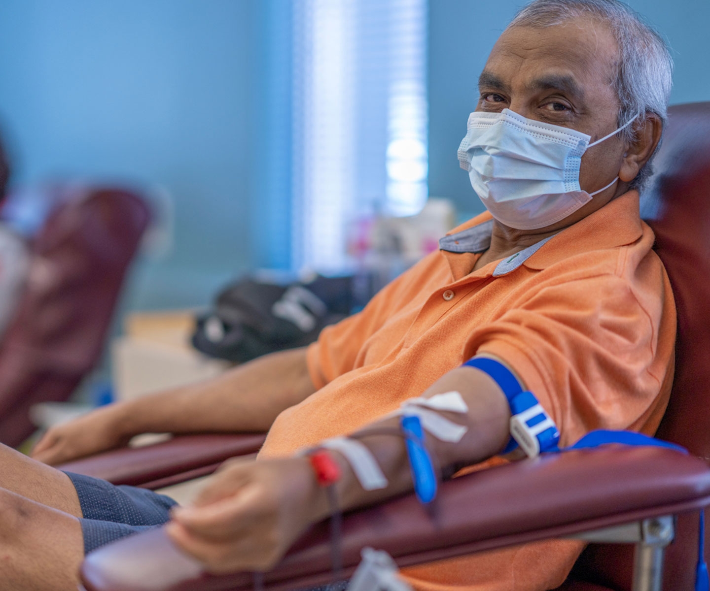 Blood donor in donation chair with arm extended