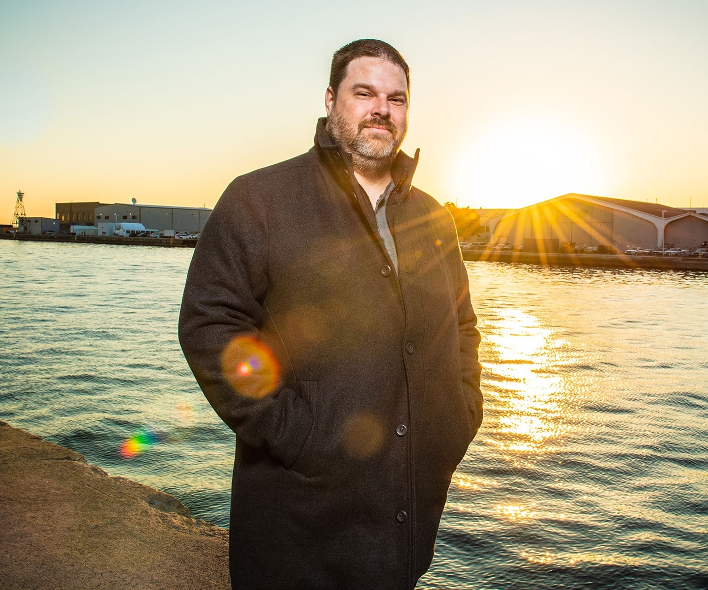 Man at waterfront at sunset on a fall day