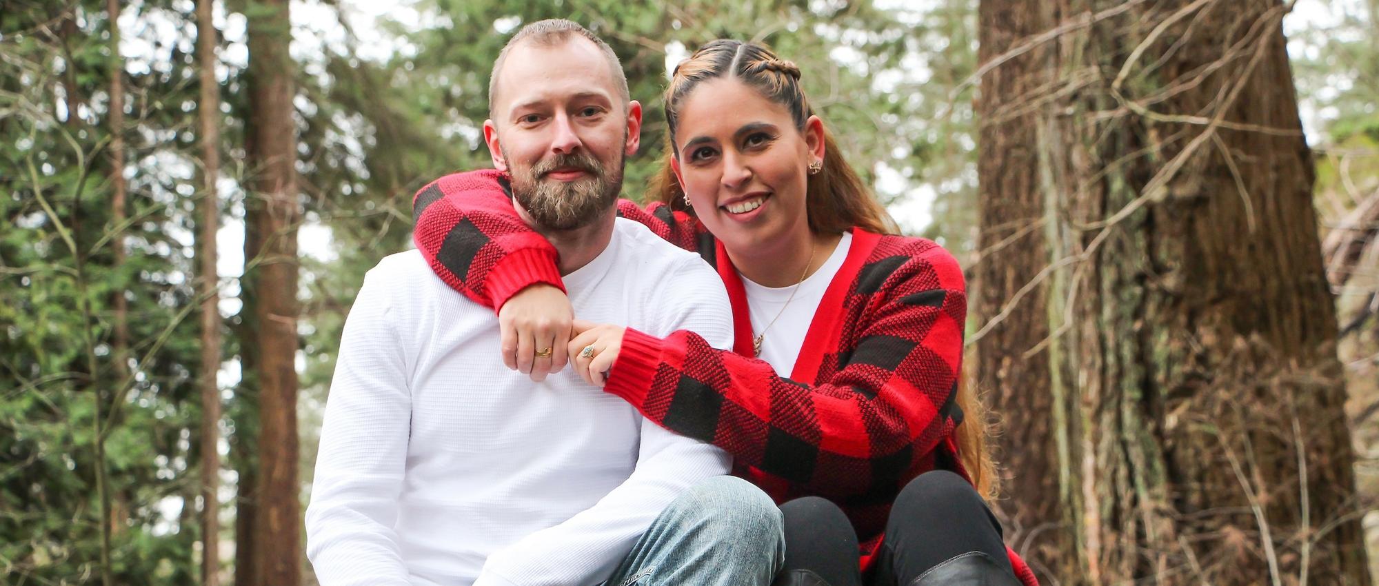 Cord blood donor Lena Mallary and her partner Cory Greenhalgh sit on a fallen tree in a tree park.