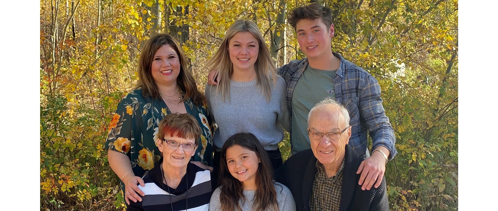 Allan and Jean Muir with their family sitting outside in the daughter's backyard