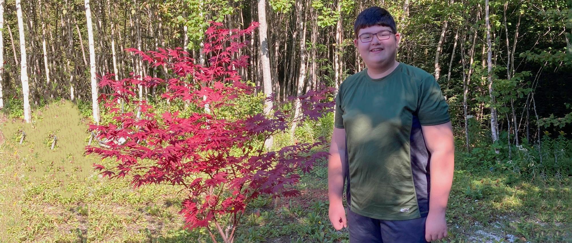 A childhood cancer survivor stands in his yard at the start of the school year 