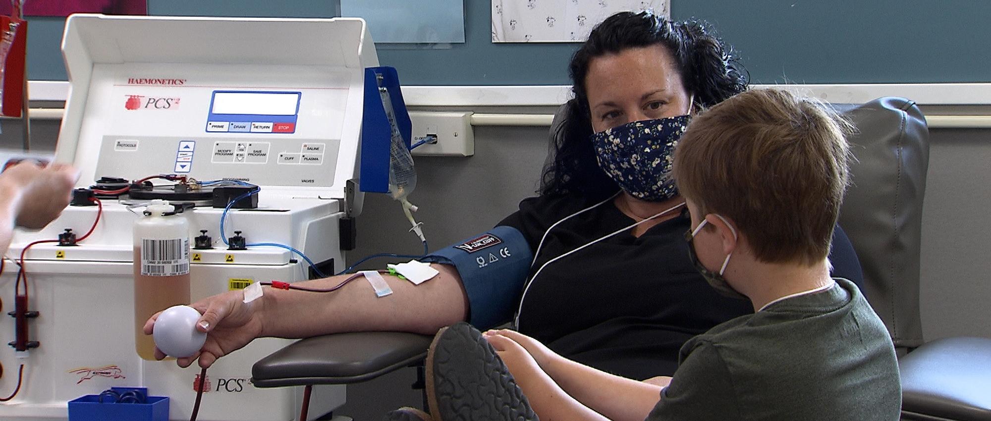 Shannon Morrison donates plasma while her son Heydan looks at her. Heydan receives medication made from plasma.