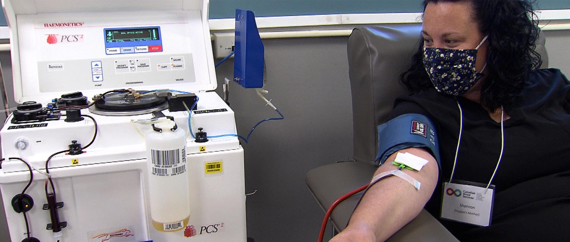 Image of plasma donor Shannon Morrison sitting in a chair hooked up to the machine to donate plasma at the new Sudbury Plasma Centre