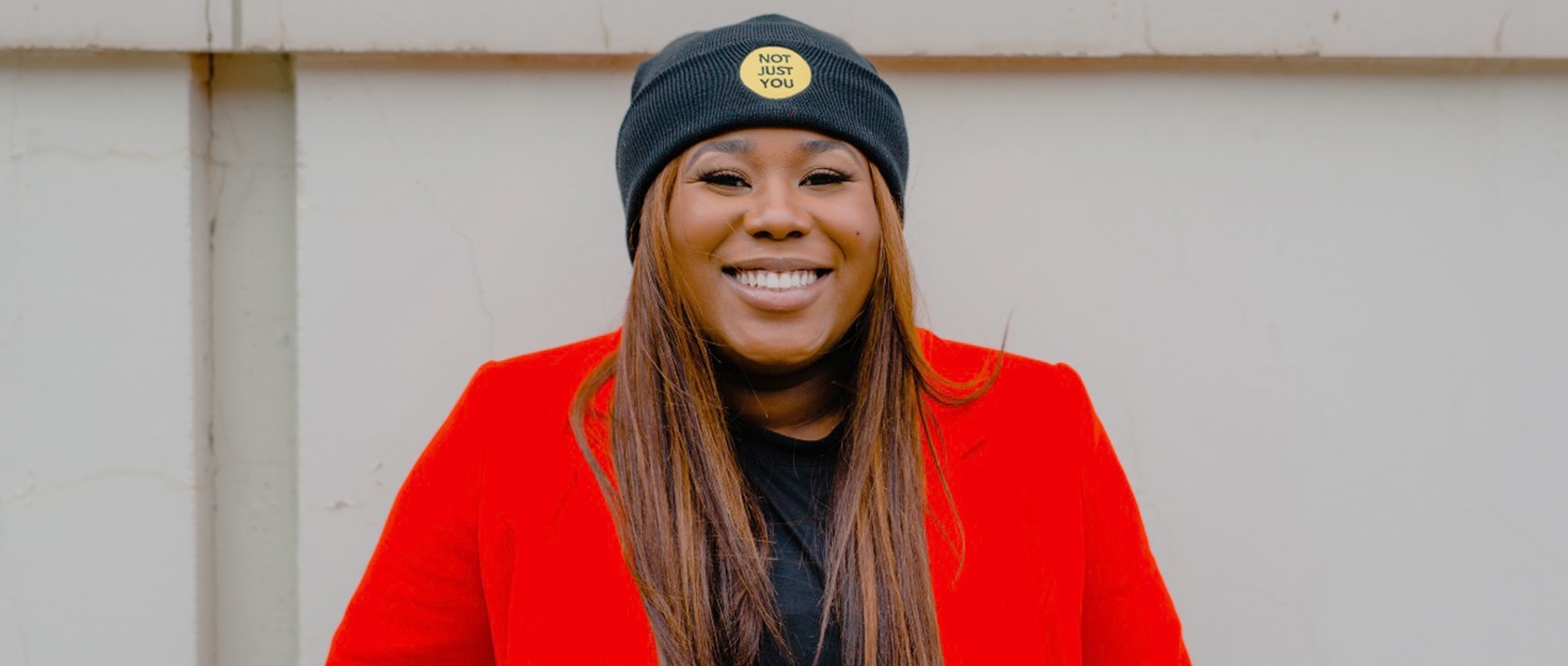 fuoma Wearing a knitted hat with NOT JUST YOU on the front