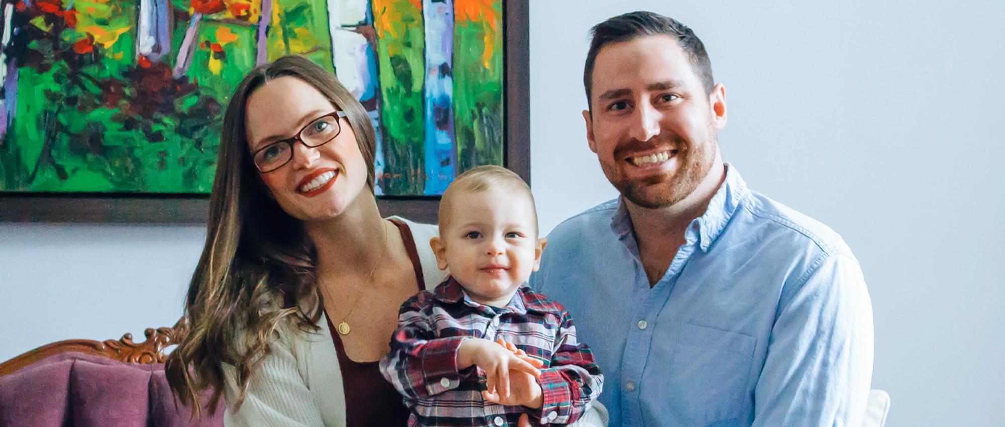 Featured image of blood donor and a registered organ donor Greg Kitchen along with wife Deanna Kitchen and son Cole Kitchen sitting on the sofa in front of a painting in their house.