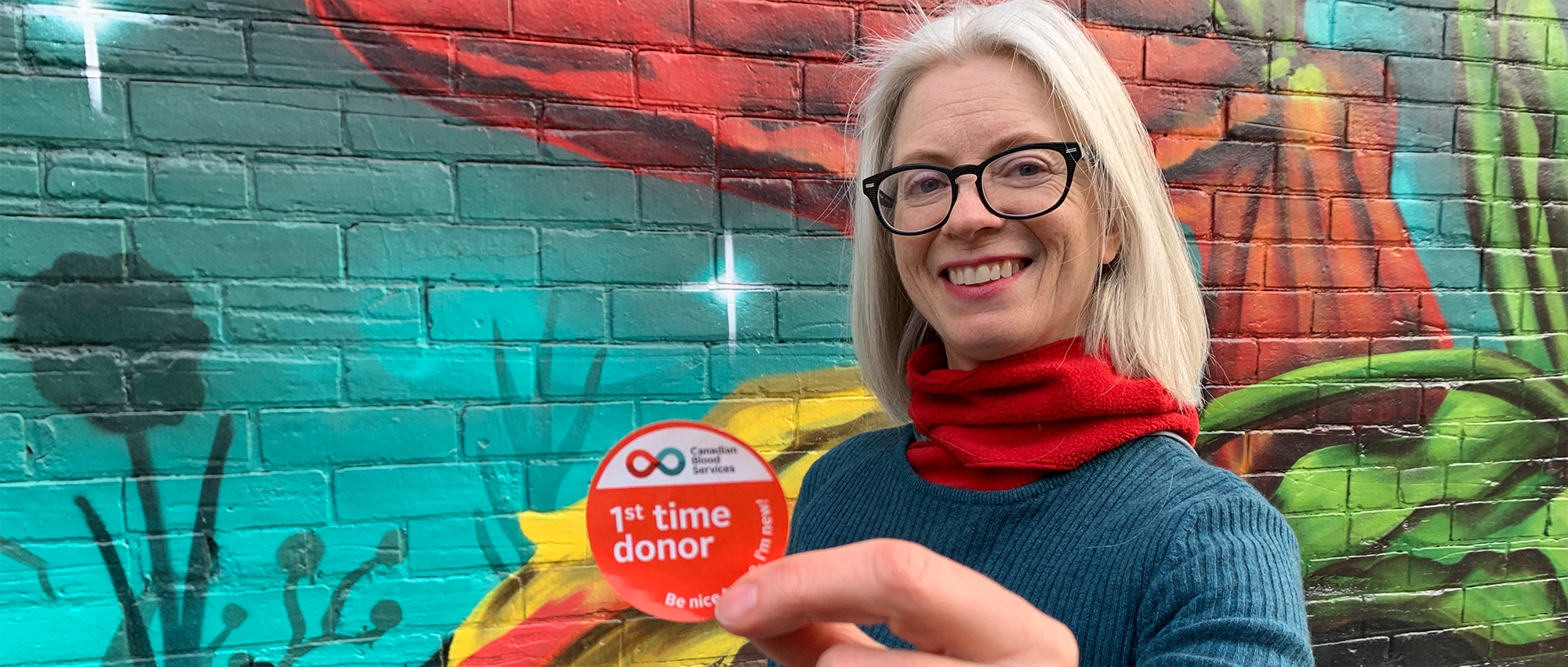 woman holding a first time donor sticker