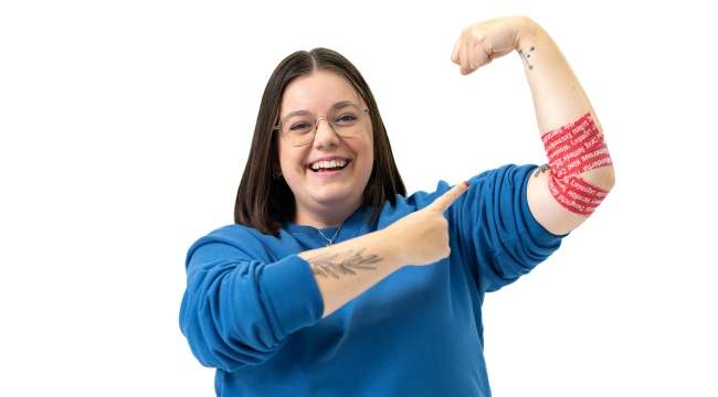 First-time donor Corina pointing at arm bandage