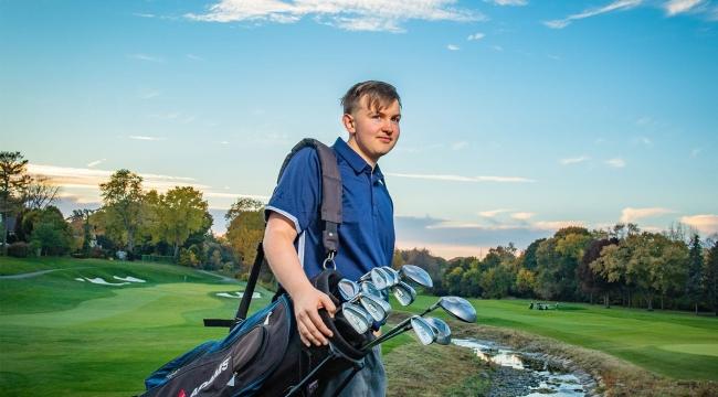 Teen blood recipient with golf clubs at golf course