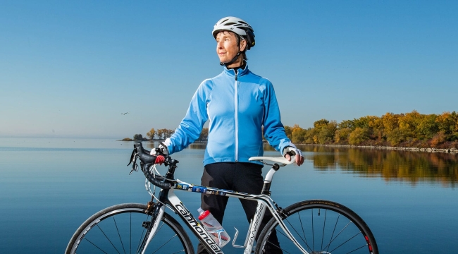 Une greffée de cellules souches avec son vélo de course sur un rocher au bord de l’eau