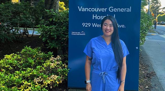 Nurse who is a living organ donor in front of hospital sign 