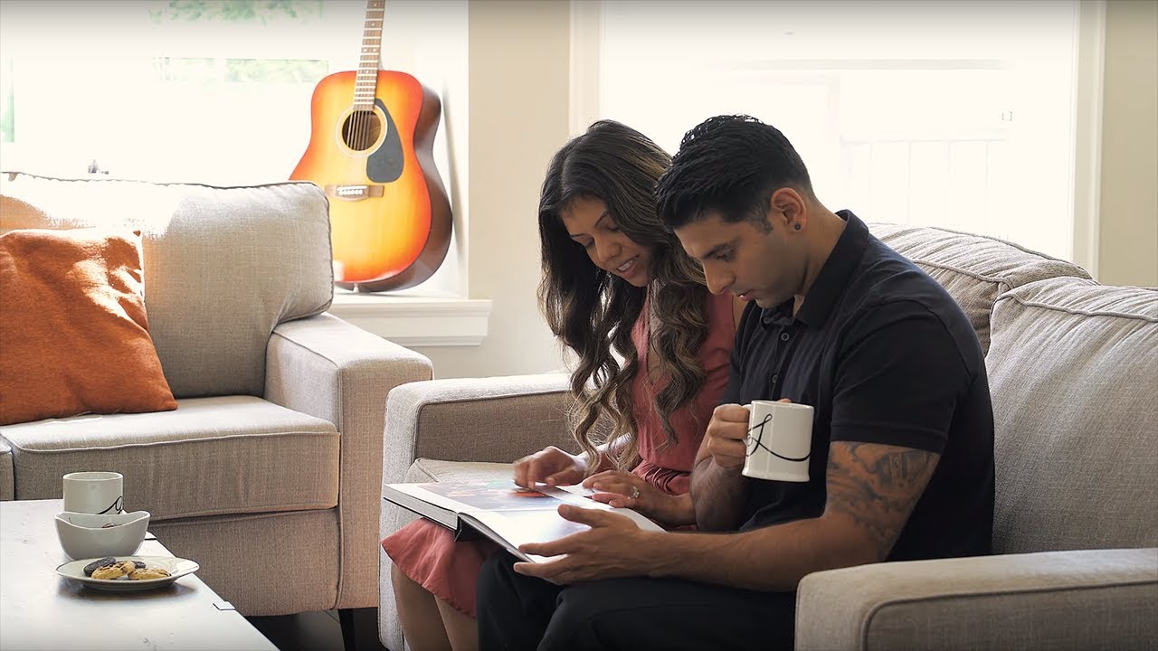 Shak and Gurjit sitting on a couch and reading a book